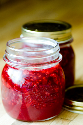 two jars with red liquid sitting on a table
