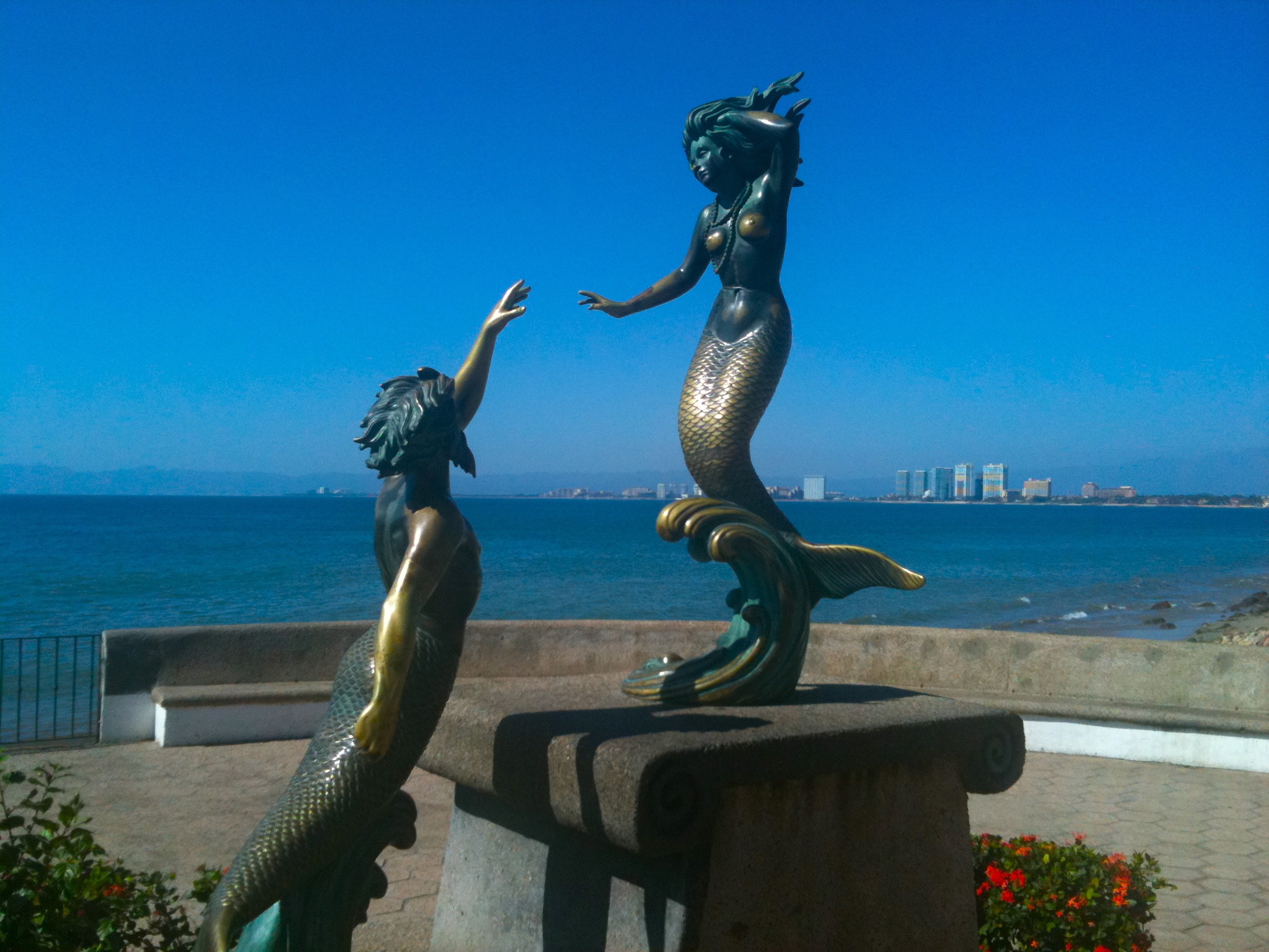 there are some statues of mermaids on the beach