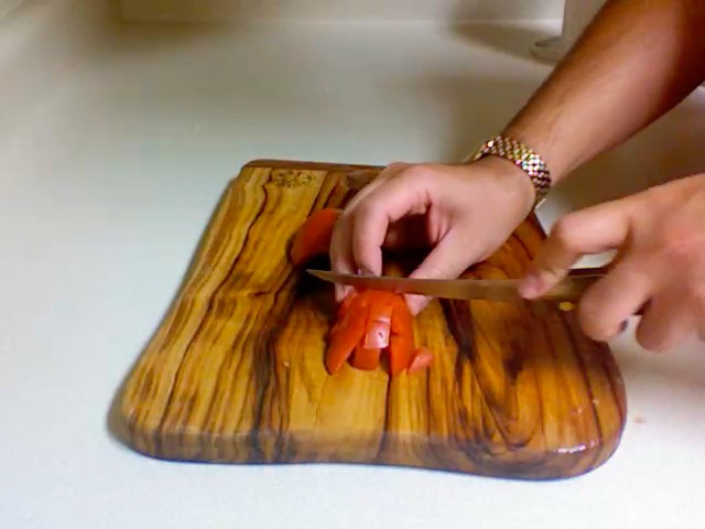 two hands  up carrots on a wooden  board