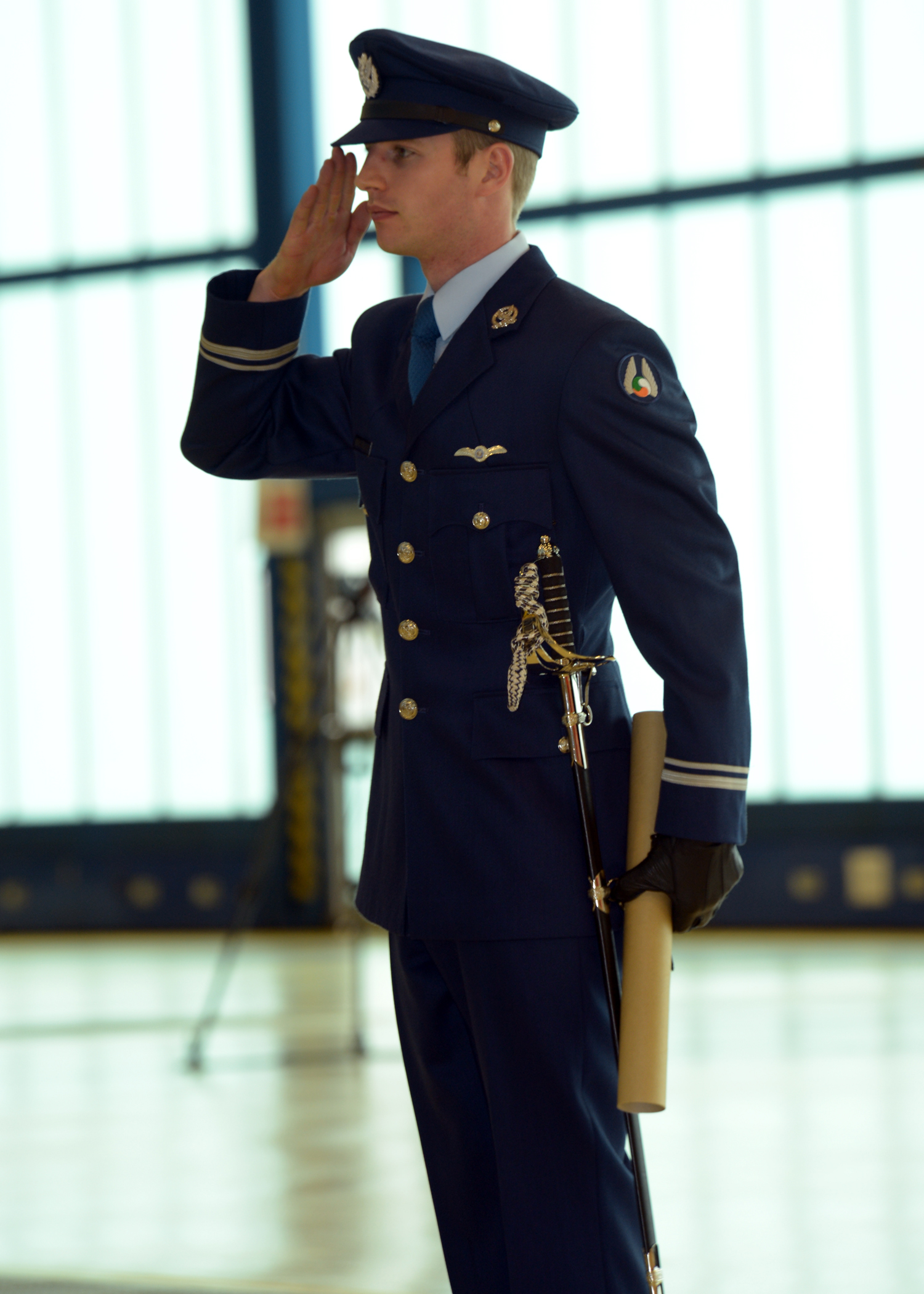 a young man in uniform, saluting in an airport