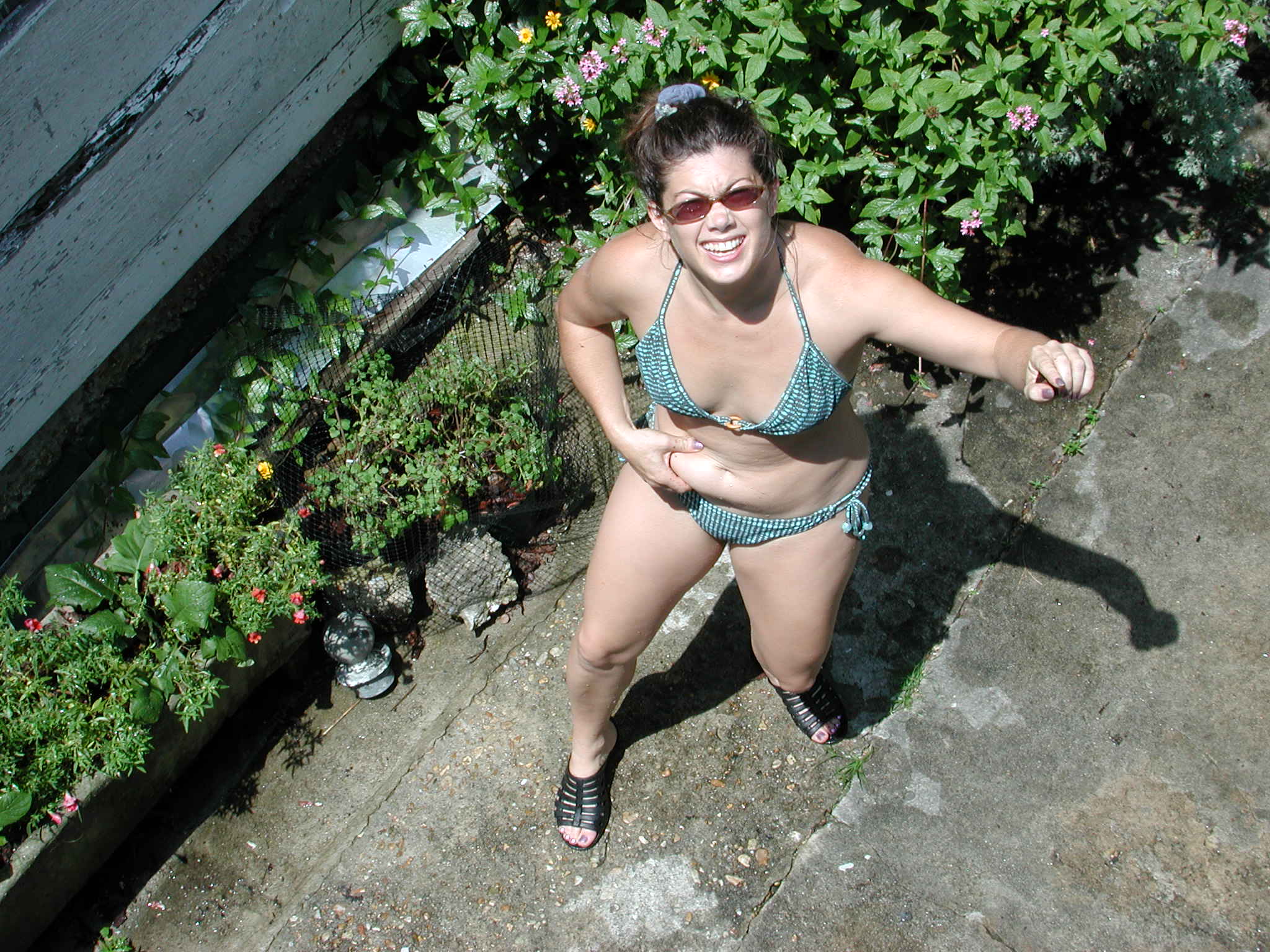 a woman with an in a bikini standing on concrete