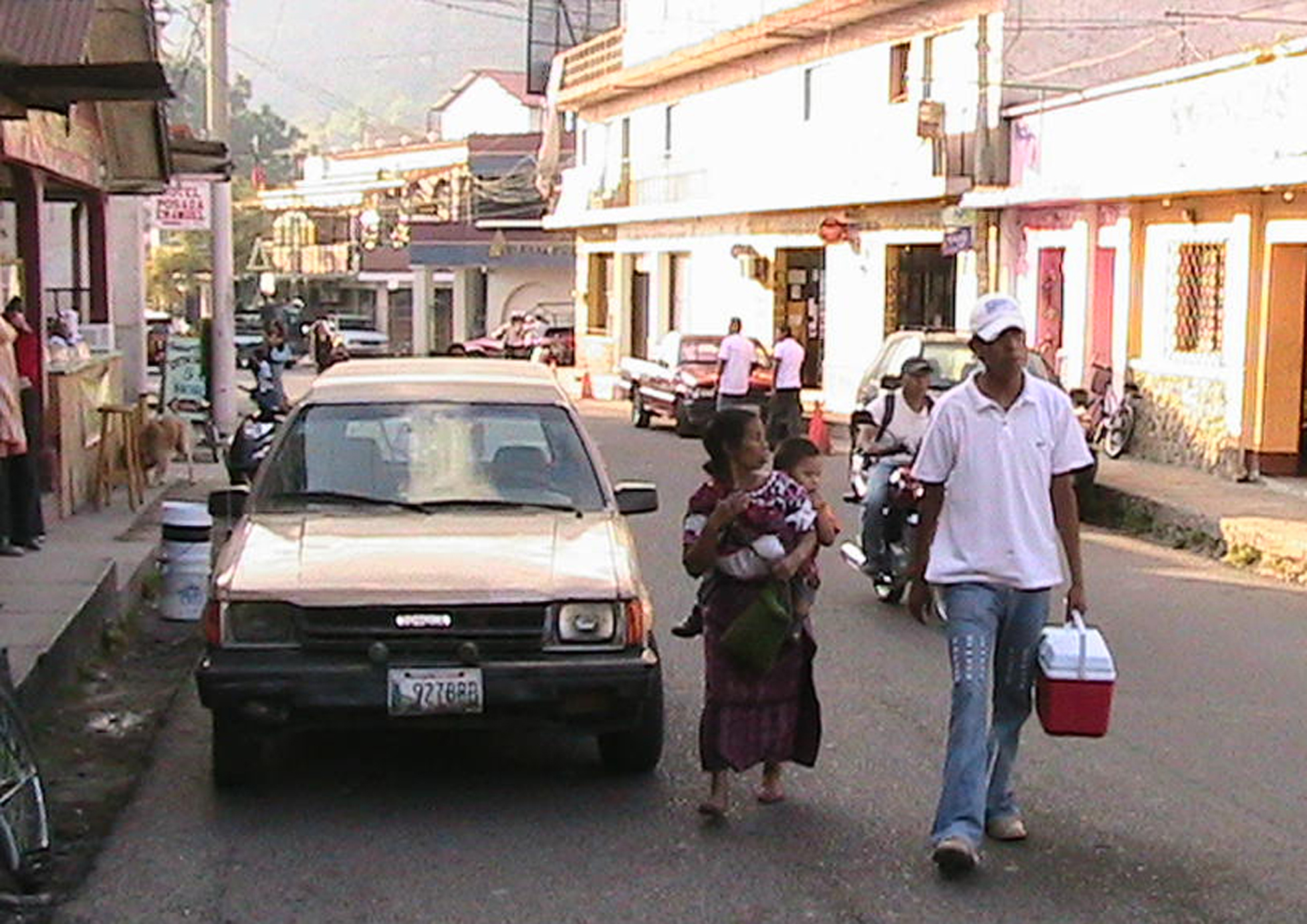 a family walks on a street as a car passes