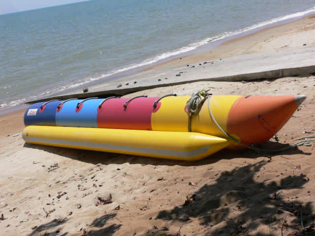 a raft tied to an orange and blue striped beach
