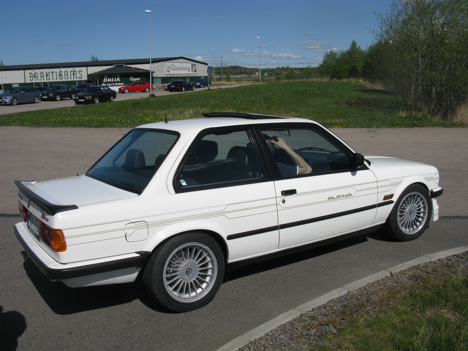 a white car is parked near the curb