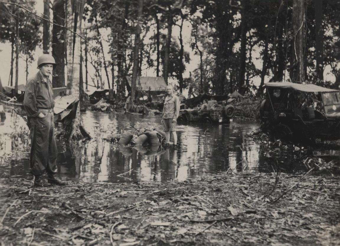 a man that is standing in the dirt near water