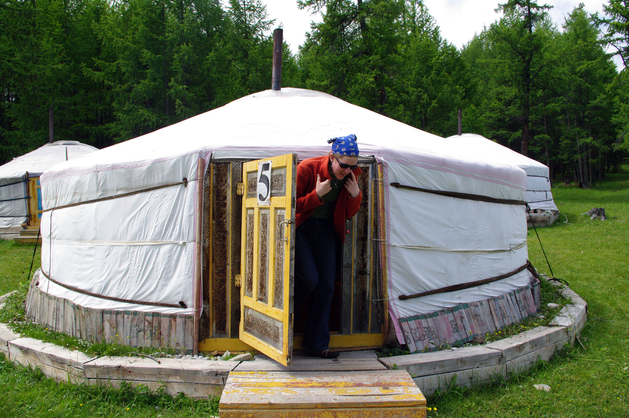 man inside a yurt speaking on a phone