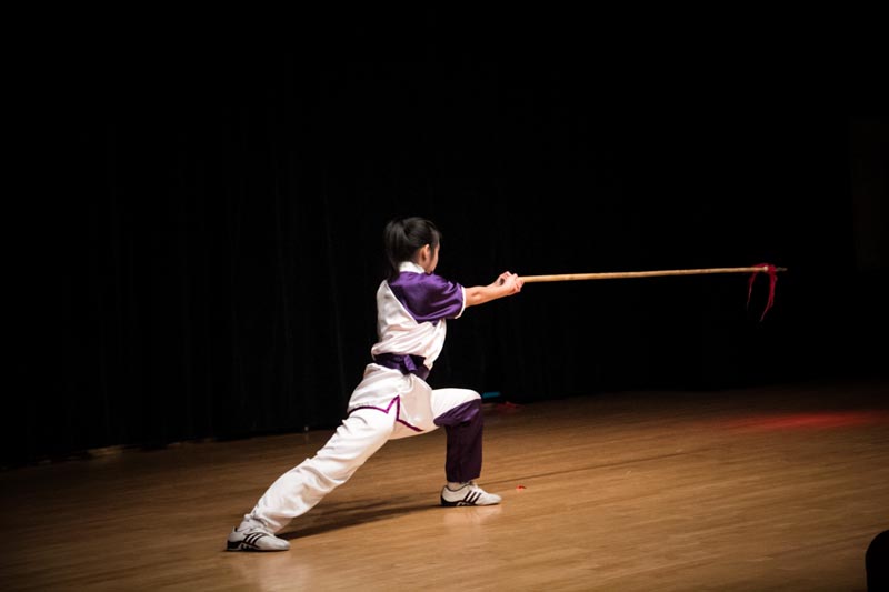 a woman practices martial style on a stage