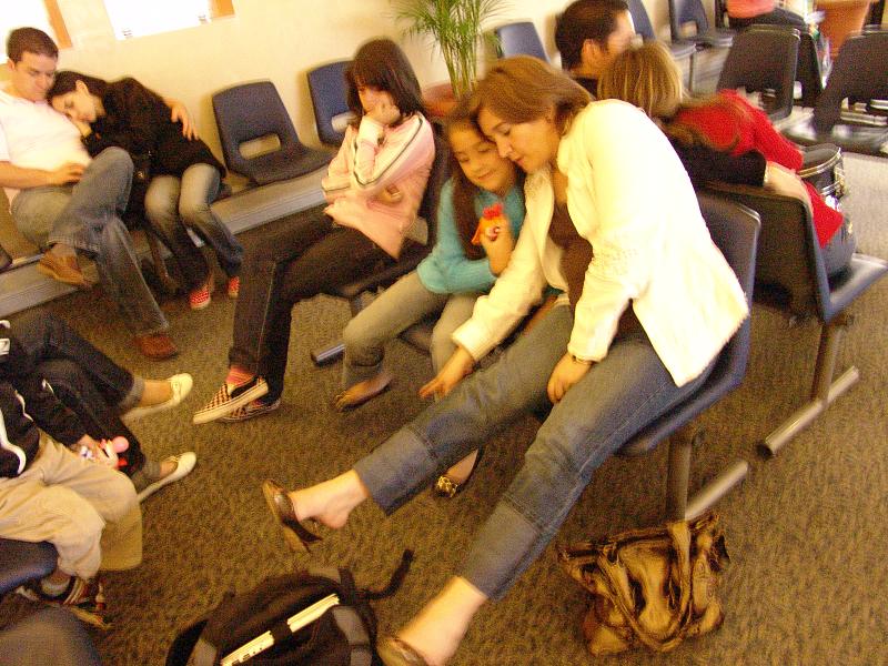 people sit in chairs and talk together inside a waiting area