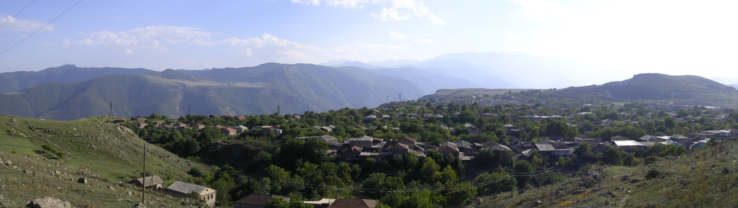 a village surrounded by mountains and greenery