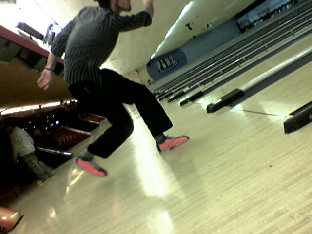 a person is skateboarding on an empty indoor bowling court
