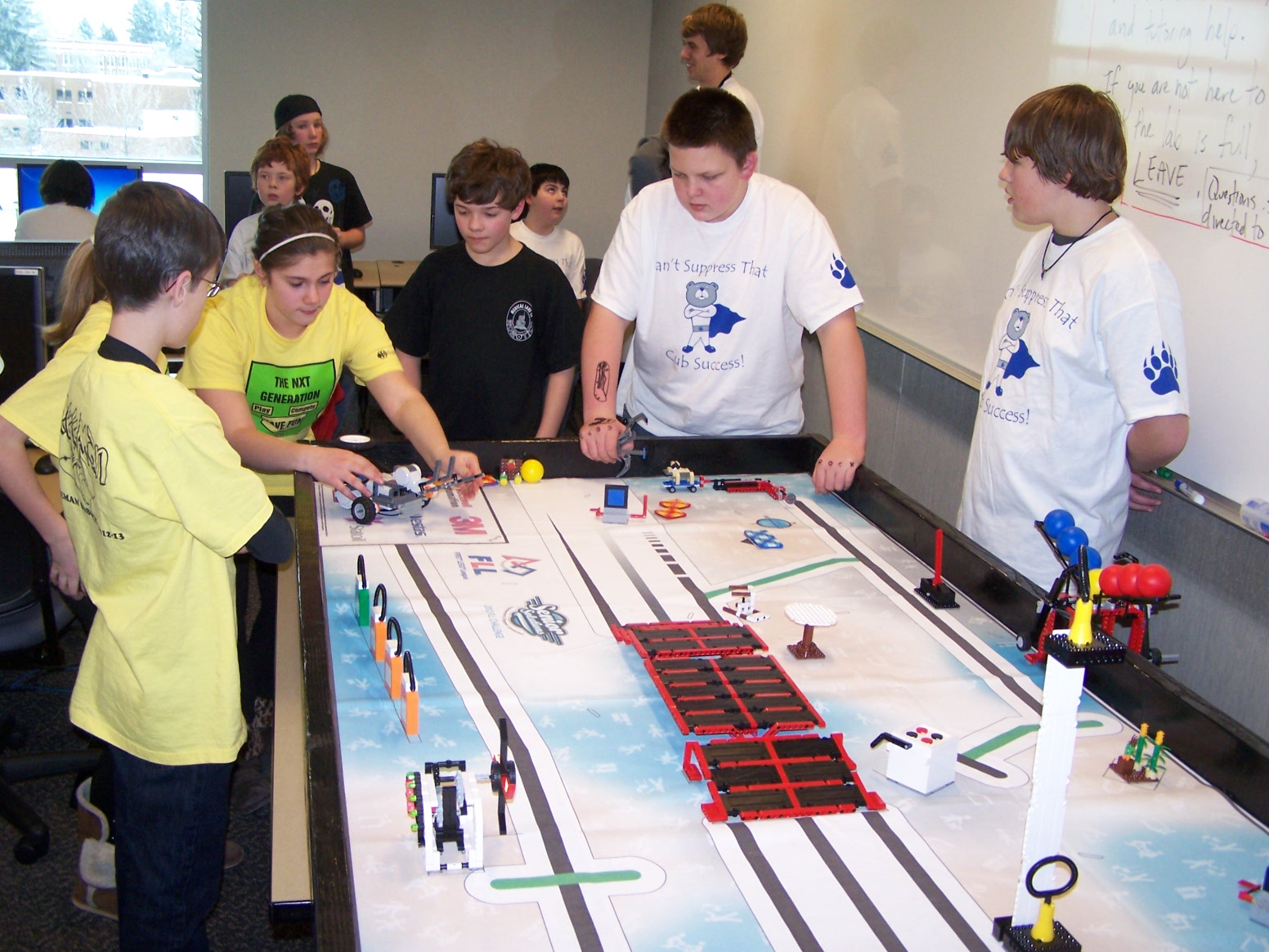 a group of people at a table with legos on it