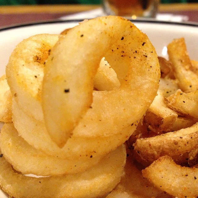 a white plate topped with fried potatoes and other food