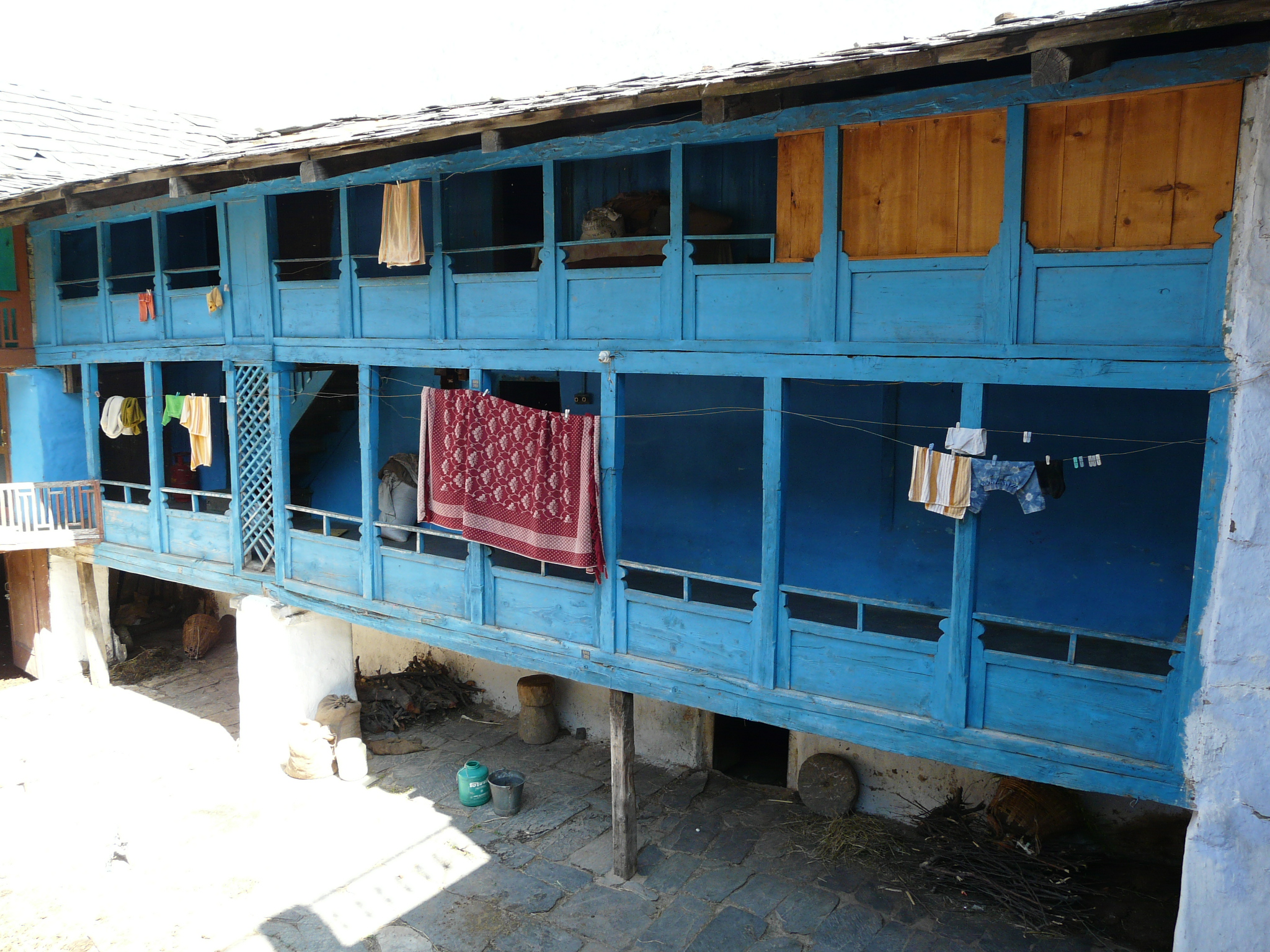 a blue building with lots of windows and cloths hung on the balcony