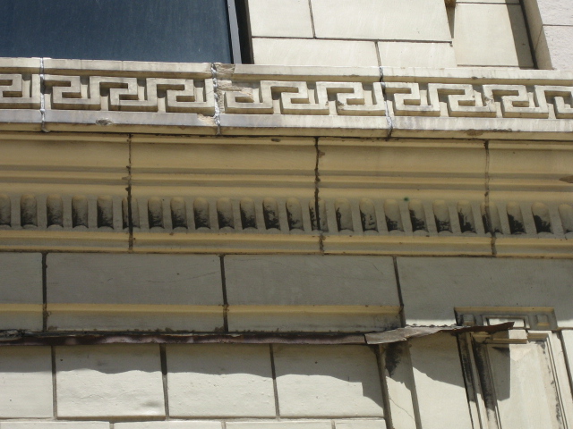 the corner of a building that is made of cement with a decorative pattern