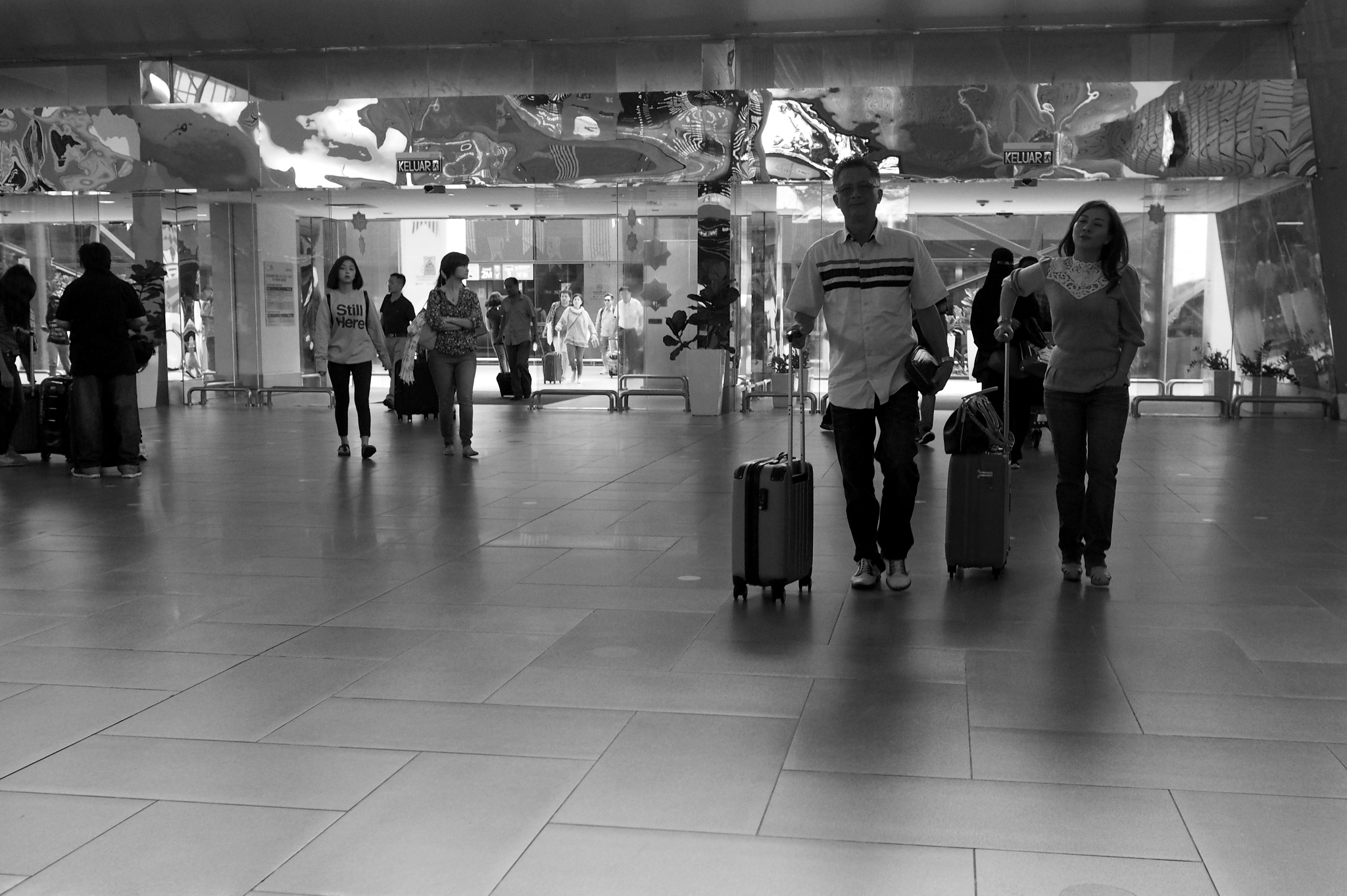 black and white pograph of several people pulling suitcases