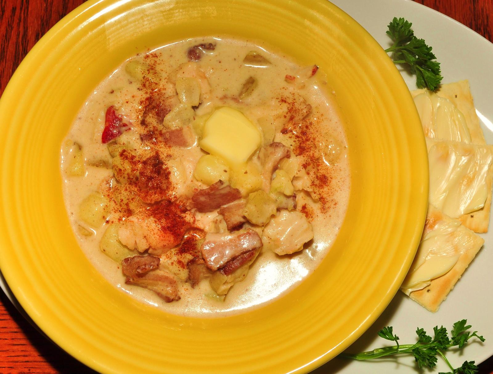 a bowl of stew sits next to some slices of bread