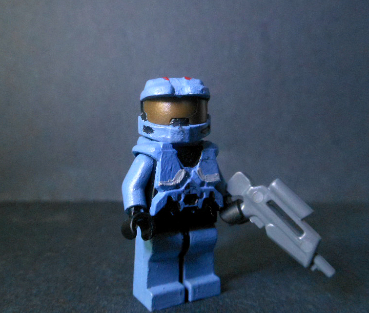 a toy is shown, and the lego has a gun in its hand