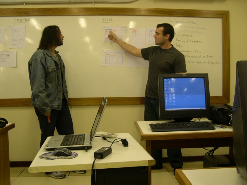 a male teacher teaching his students on computer and laptops