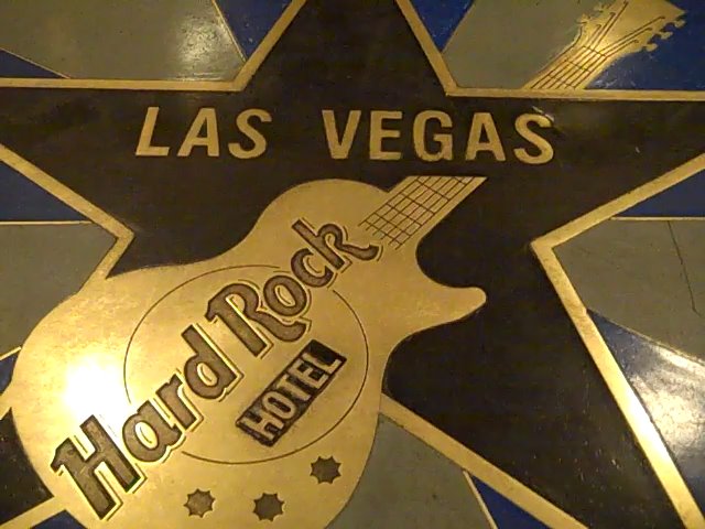 a sign that reads el el las vegas and has an acoustic guitar