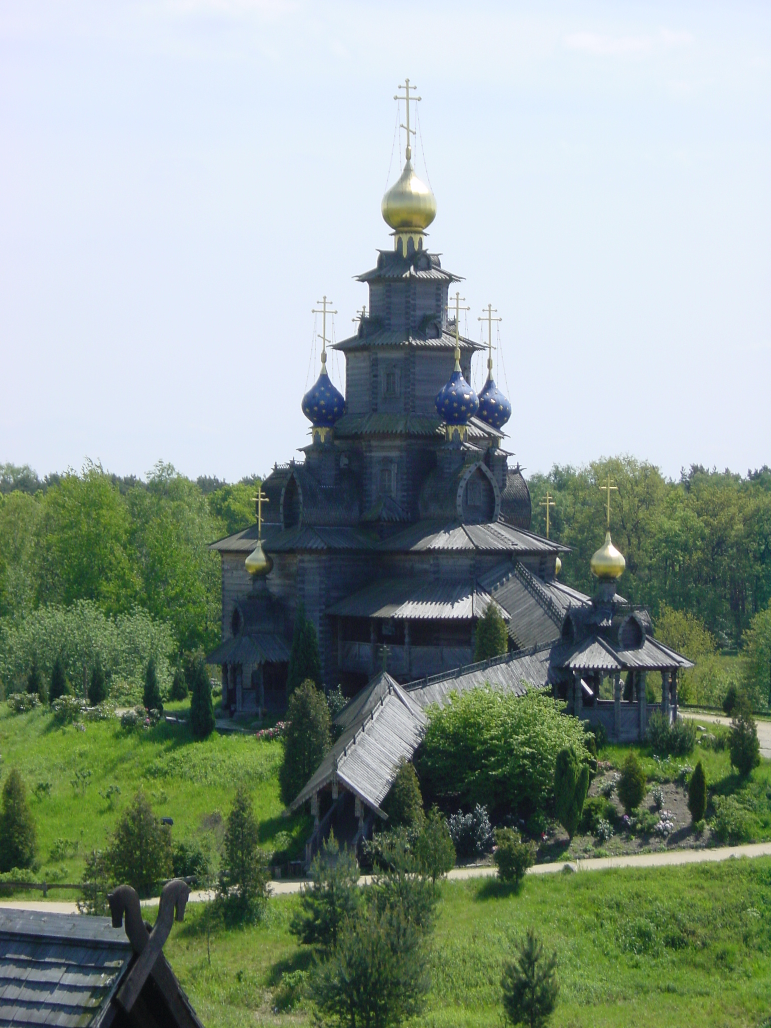 a tall church surrounded by trees and grass