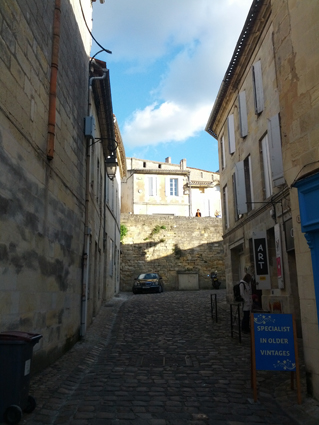 a narrow street with cobblestones and some buildings