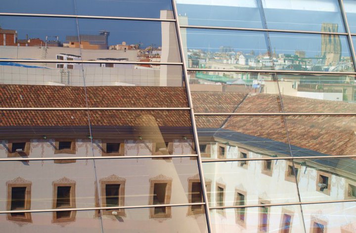 buildings in the reflection of the windows in an office building