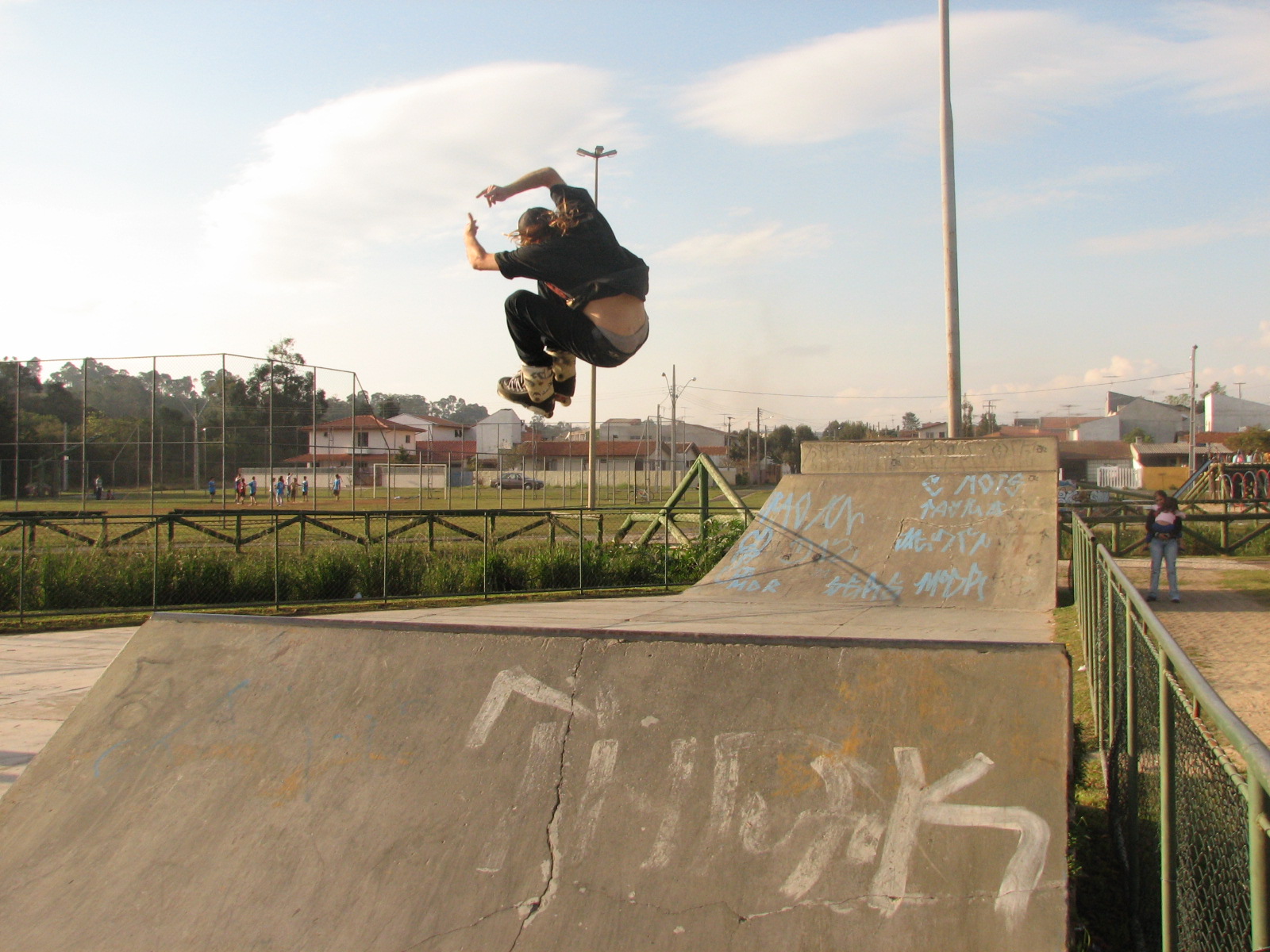 a skateboarder doing tricks in the air at a skate park