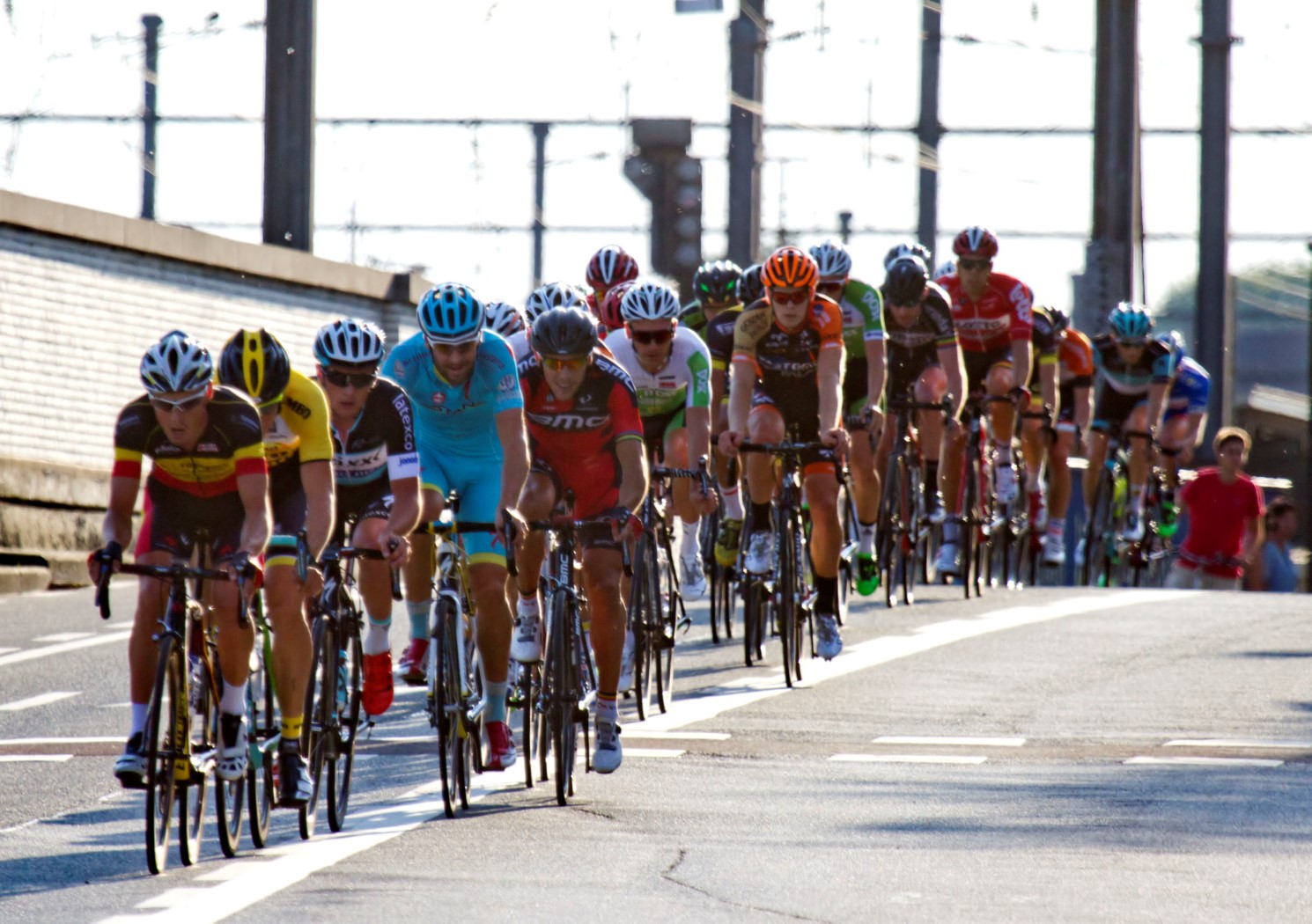 a group of bicyclists riding down a street together