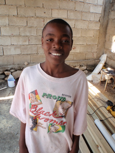 a child standing outside in front of a wall