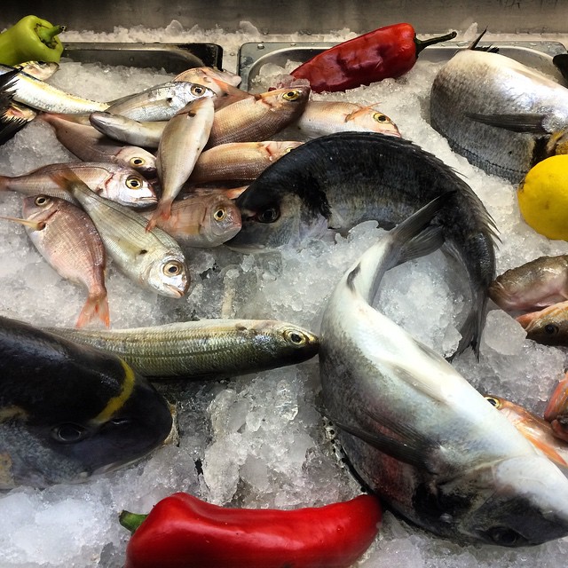 an assortment of different seafood on ice and peppers