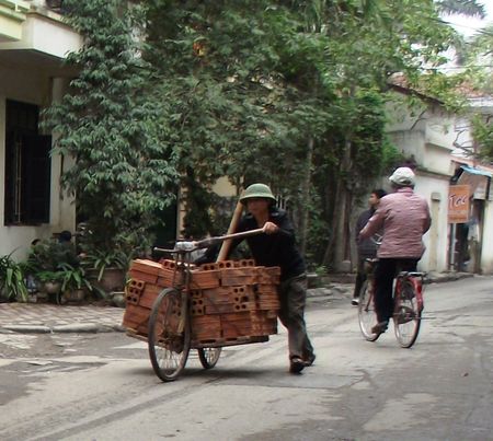 a man riding a bike down a street with lots of boxes on the back