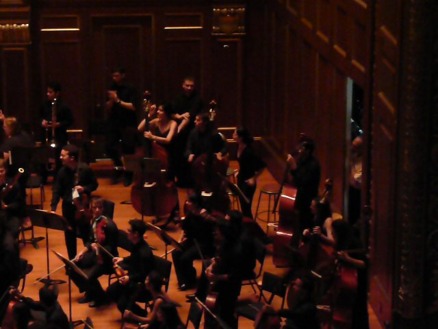 an orchestra in a large room with instruments and conductor