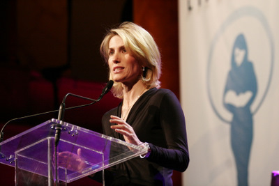 a woman standing at a podium while giving a speech