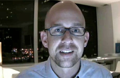 a balding man with glasses smiling at the camera