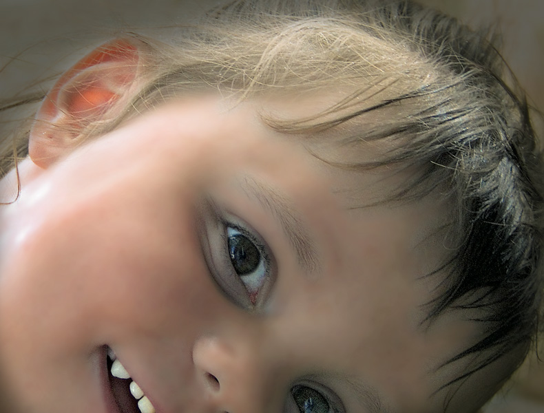 a little girl with big blue eyes wearing an earpiece