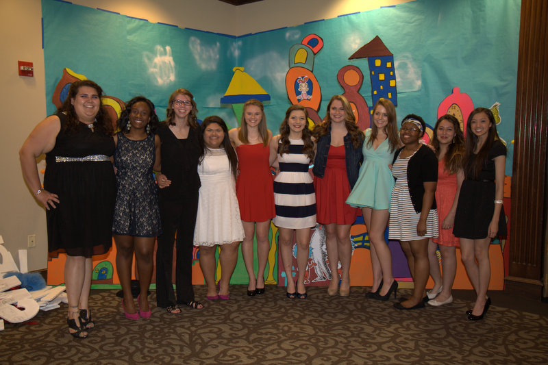 a group of girls in dresses posing for a picture