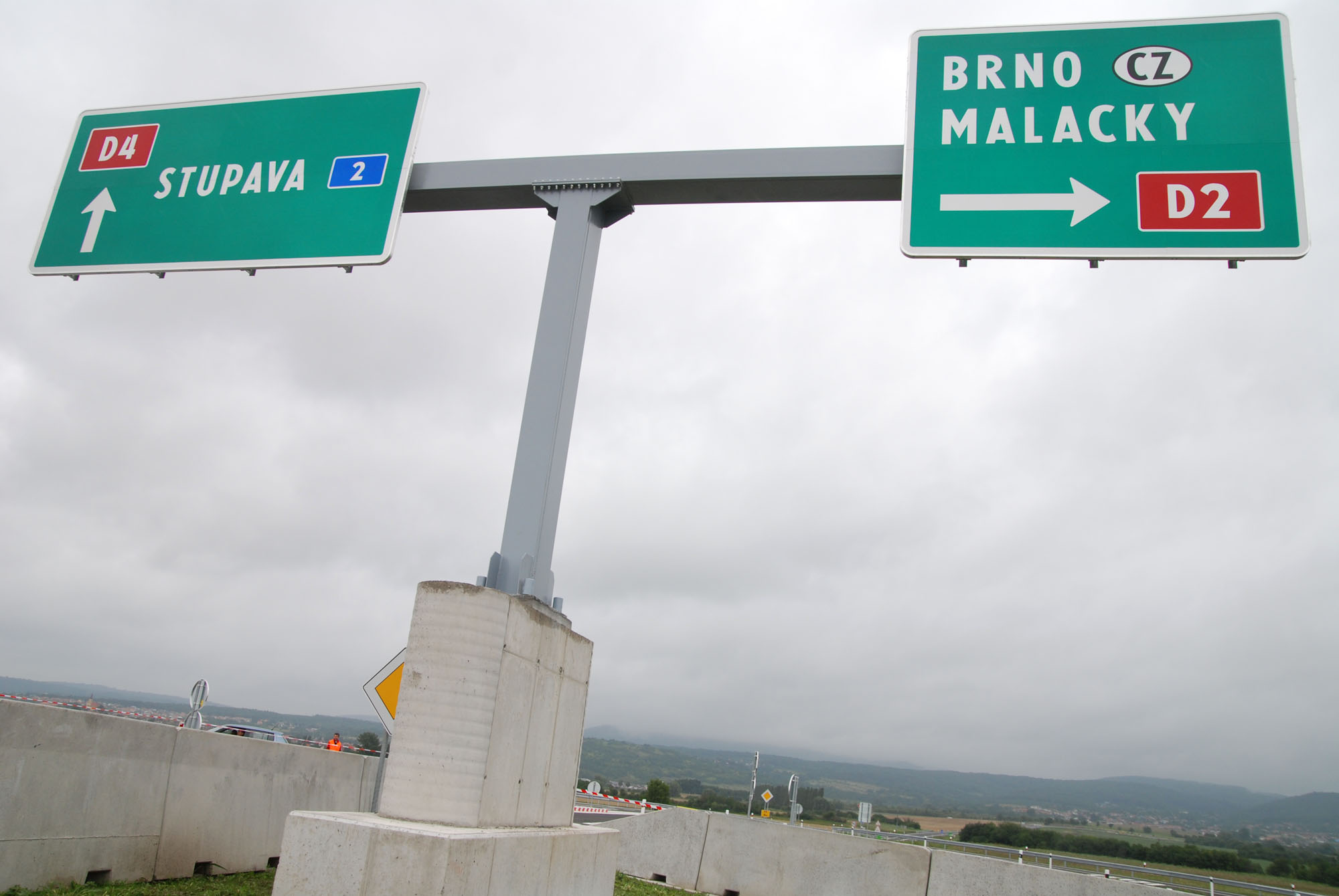 street signs on metal and concrete posts pointing in opposite directions