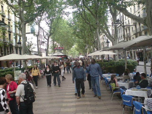 a city street is lined with several open umbrellas