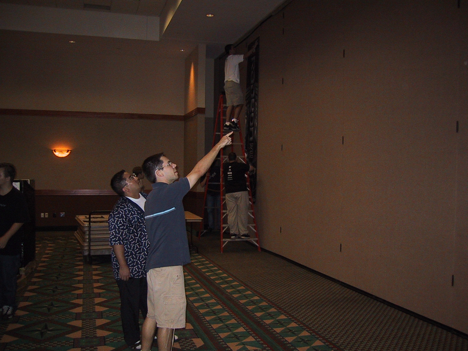 two people in an elevator and one person holding soing up