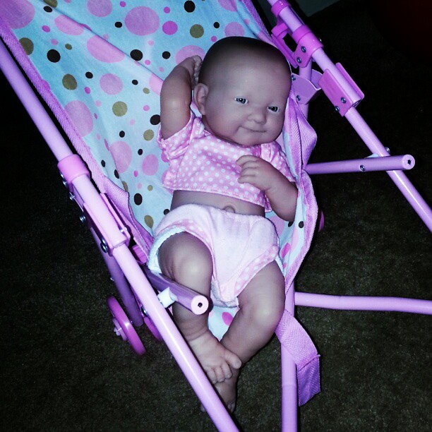 baby doll is sitting on her pink hchai