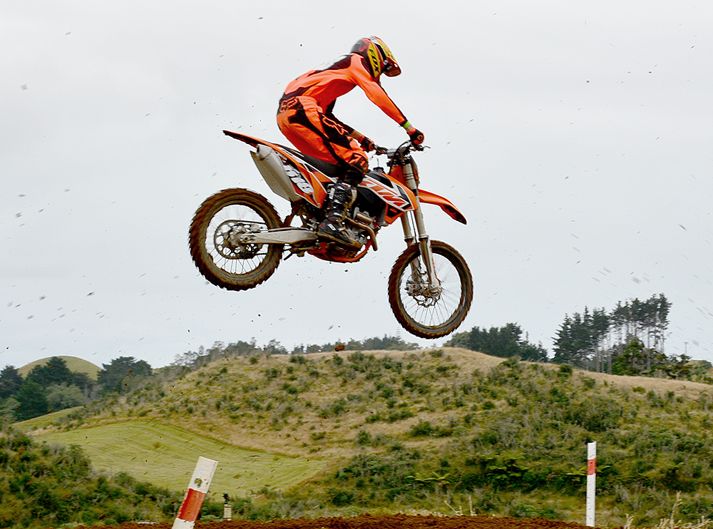 a motorcyclist jumping a dirt bike in the air