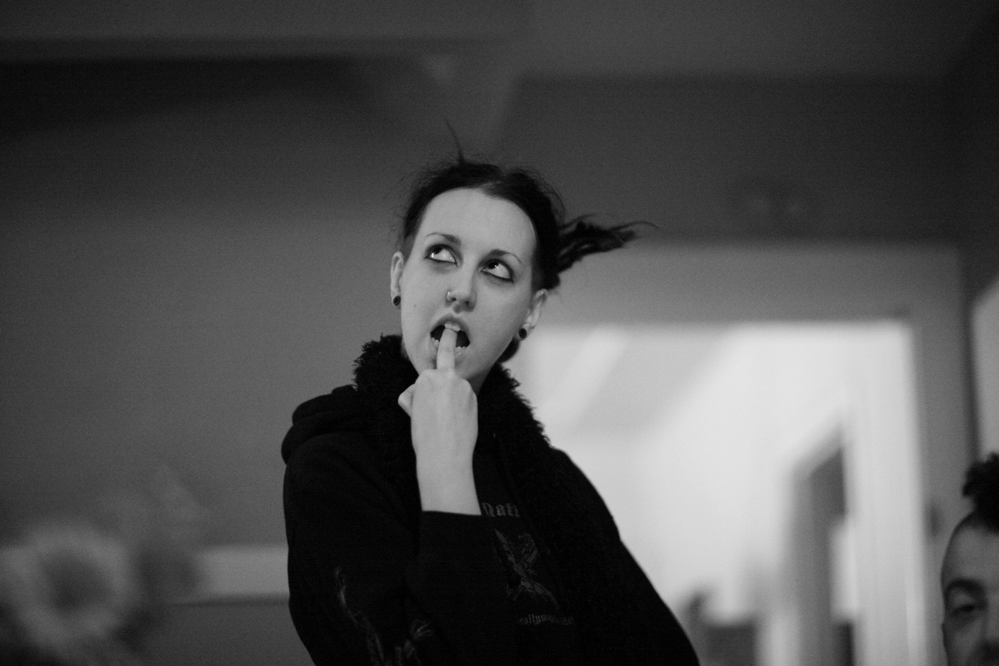 black and white image of a young woman looking in a mirror with a cigarette