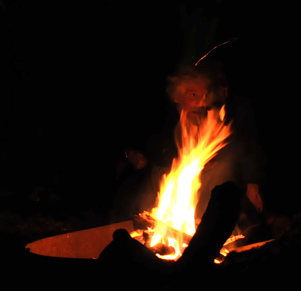 a person sitting in front of a lit fire