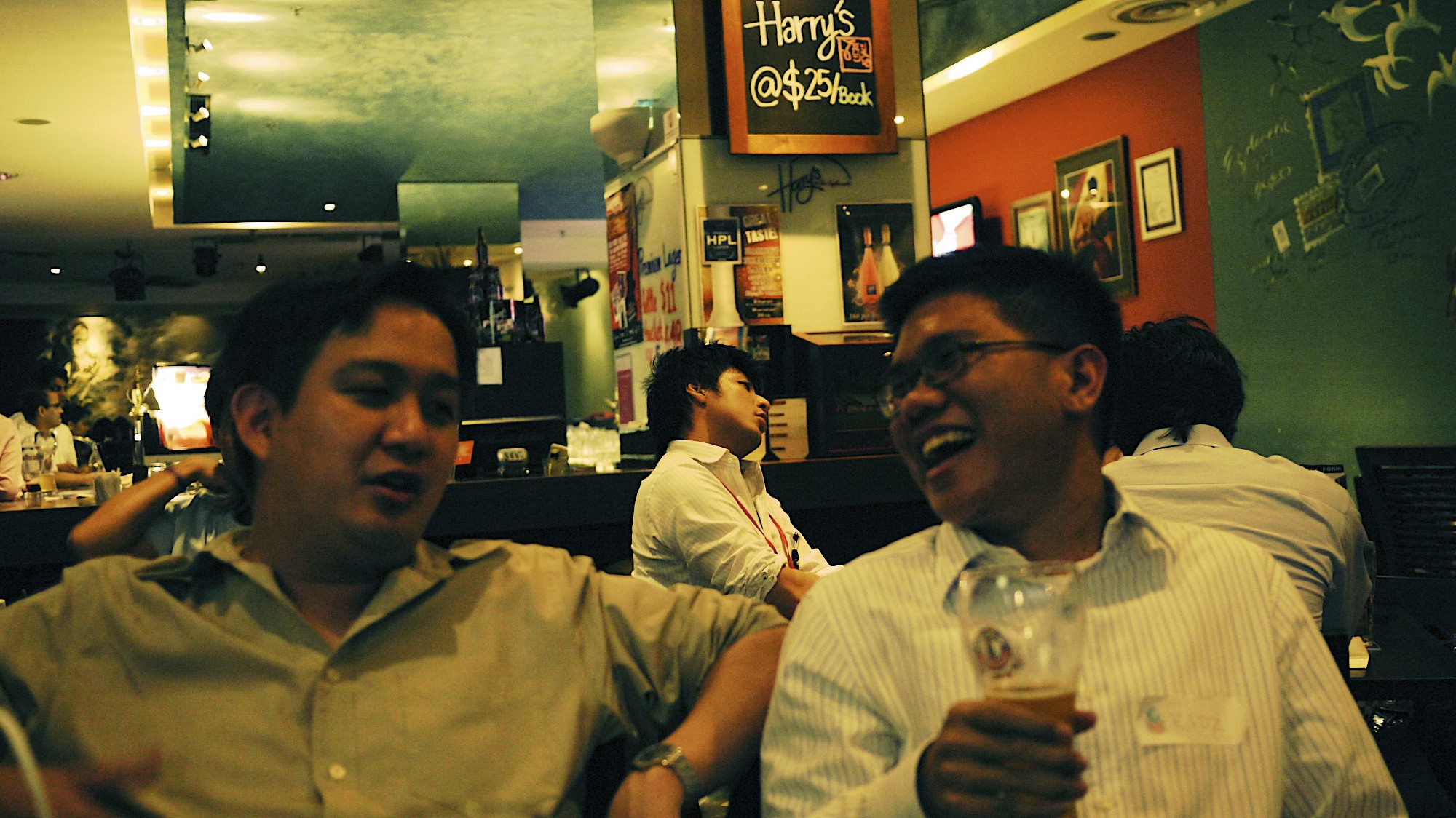 two men siting together and drinking at a restaurant