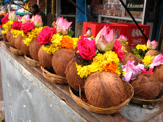 colorful flowers line the sides of baskets in a market