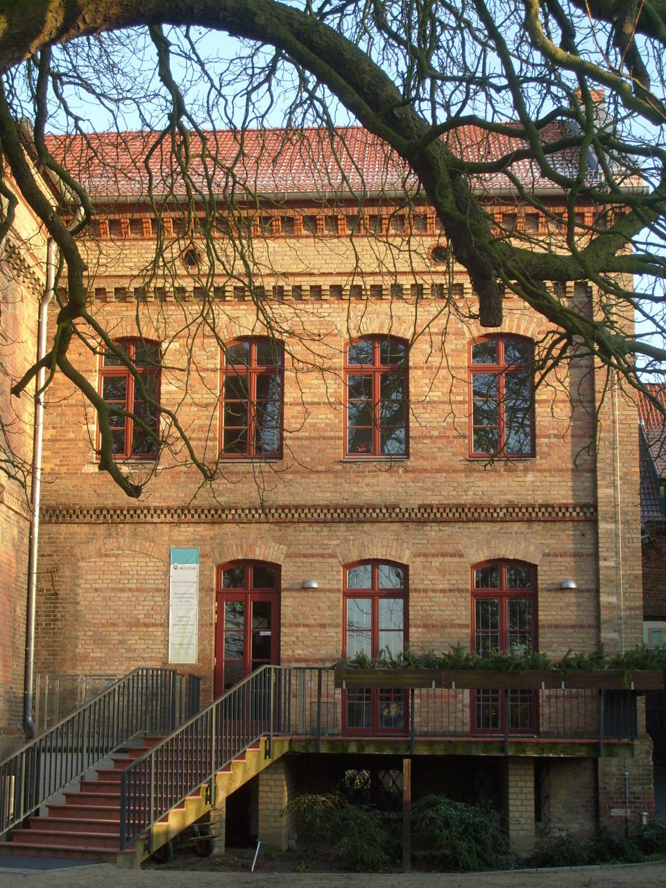 a large brick building that has a red door and windows on the top level