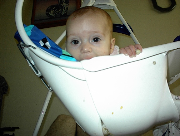 the baby is holding on to his high chair