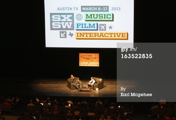 two people are on stage at the music and film interactive convention