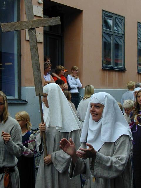 people dressed in cloths and holding wooden crosses