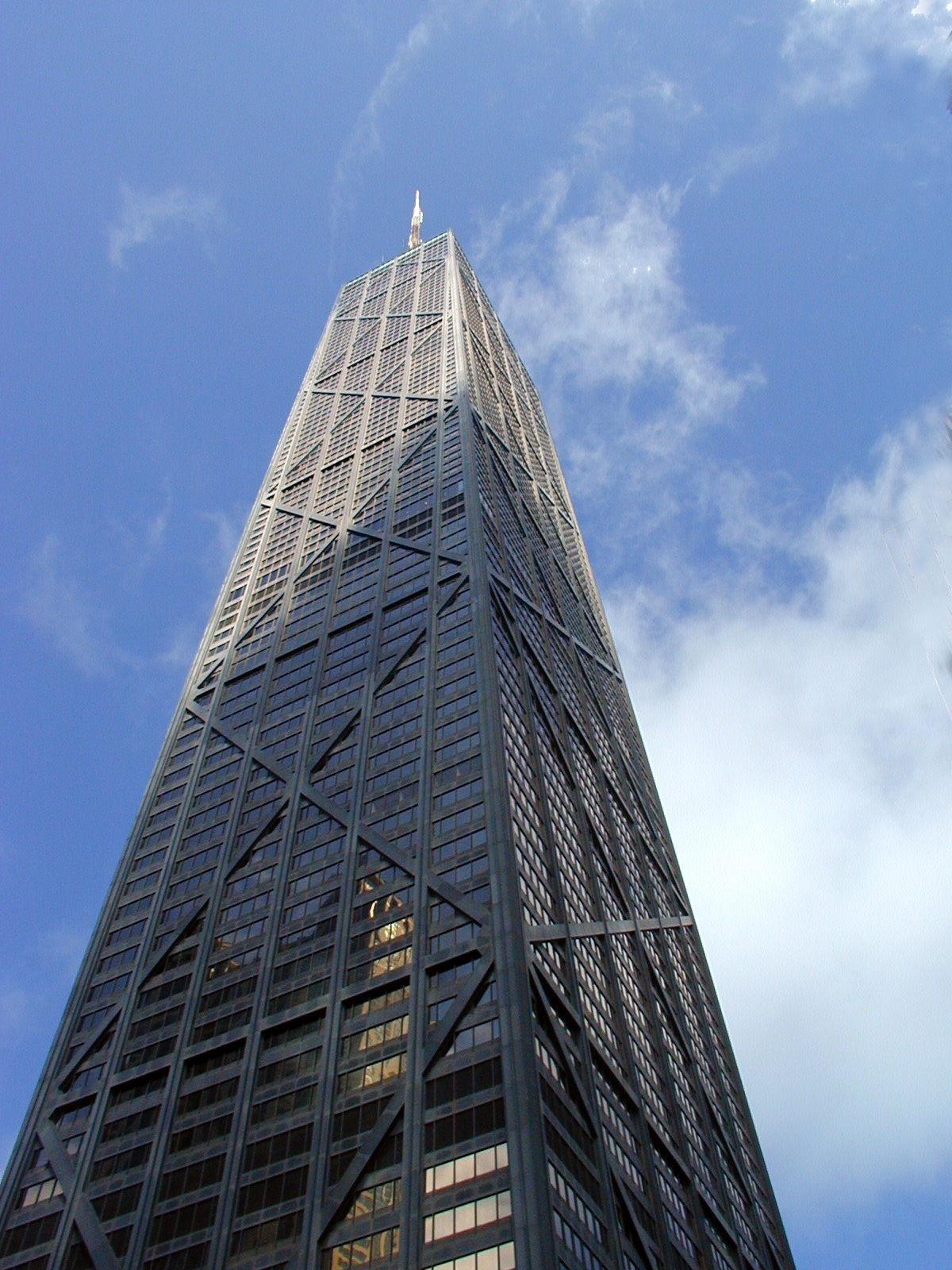 the top of a tall glass building against a blue sky